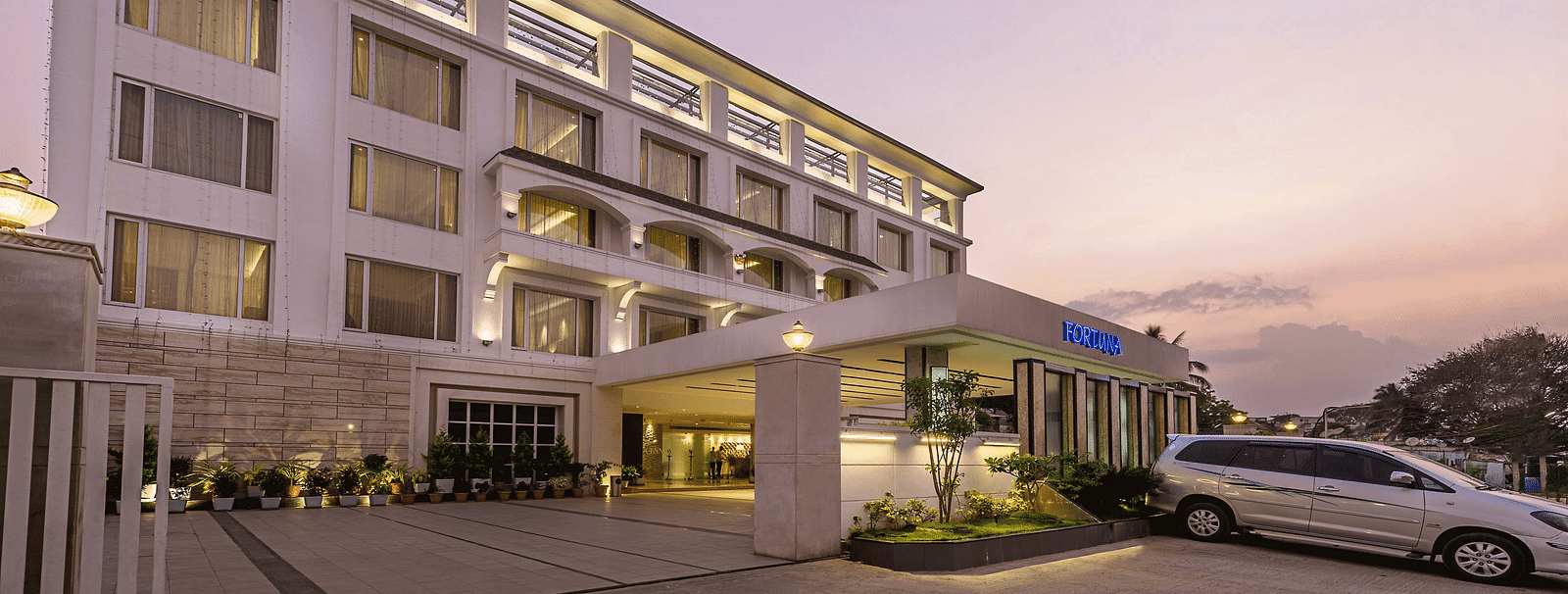 The exterior of the TGI Grand Fortuna Hotel during twilight, showcasing its entrance and facade - TGI Grand Fortuna, Hosur