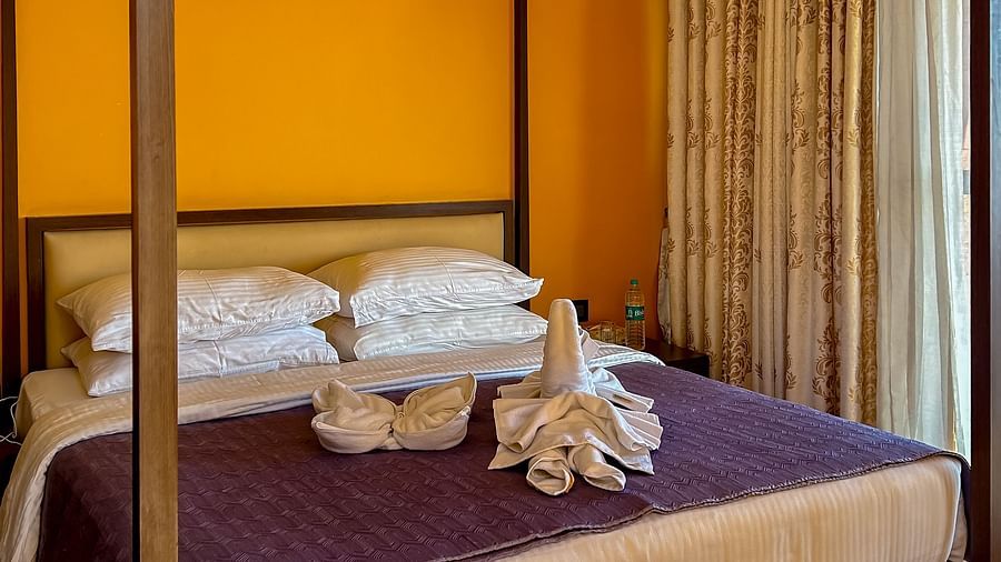 Elegant four-poster bed in a cozy room with wooden flooring at Aranya Himalayan Retreat, Mashobra