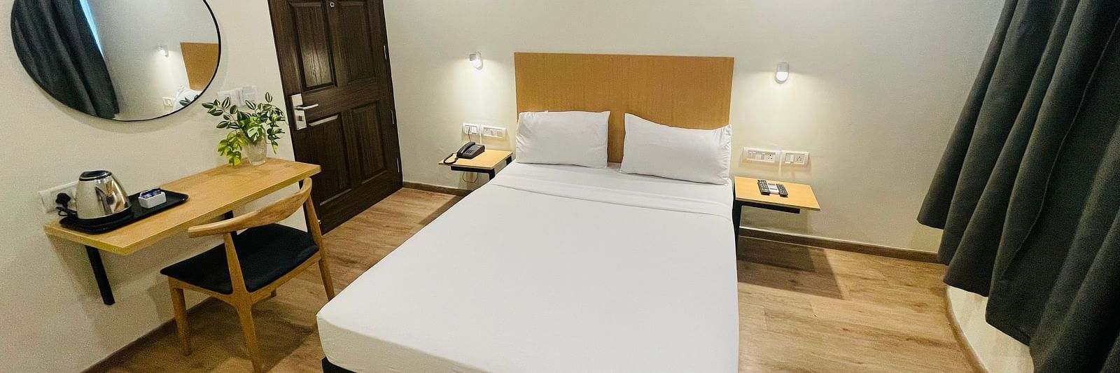 A double bed and a work desk at Sanctum Suites Richmond Road, Bangalore
