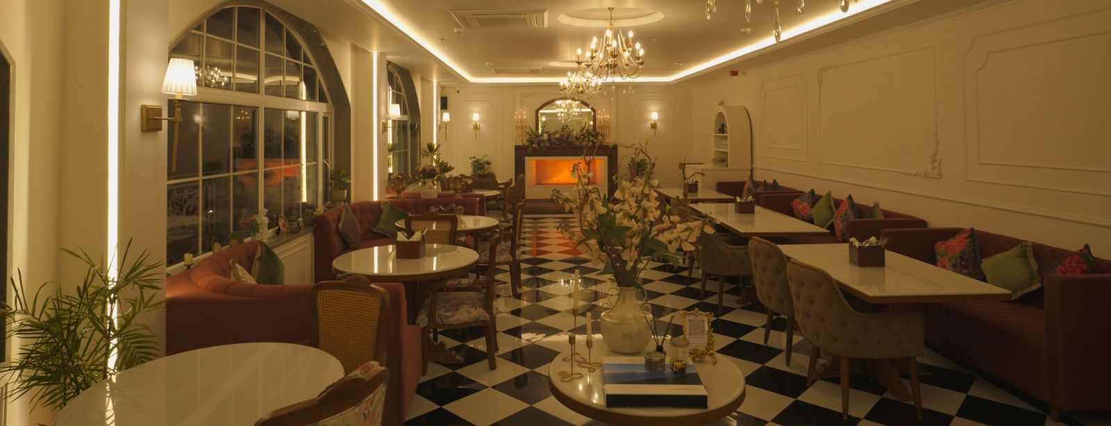 Classy dining area with black-and-white flooring, chandeliers, and booth seating - Mayfair Cafe & Suites, Dalhousie