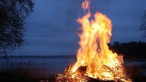 A bonfire amidst the surrounding of a lake