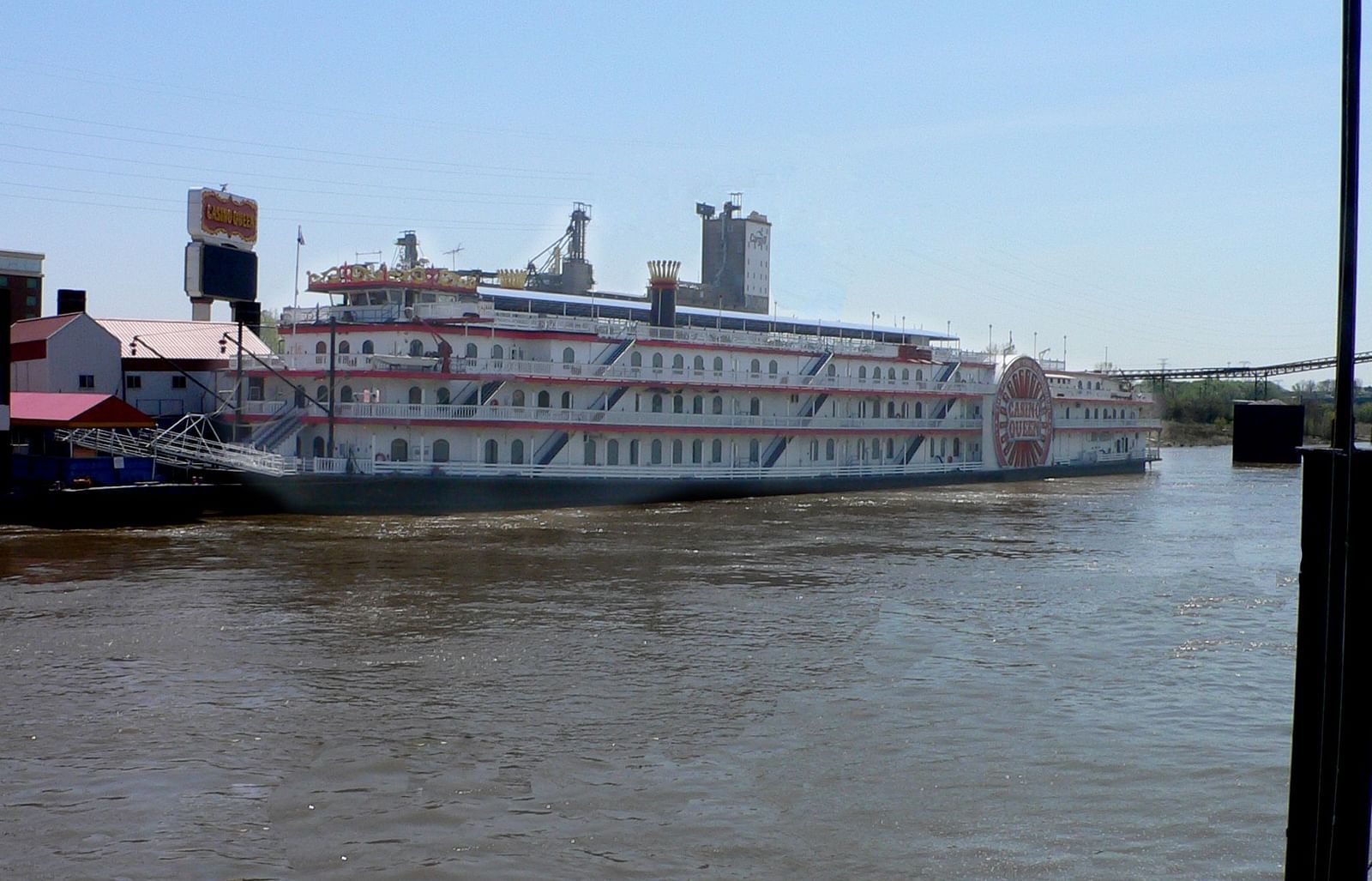 A ship named Casino Queen standing at the shore in broad daylight