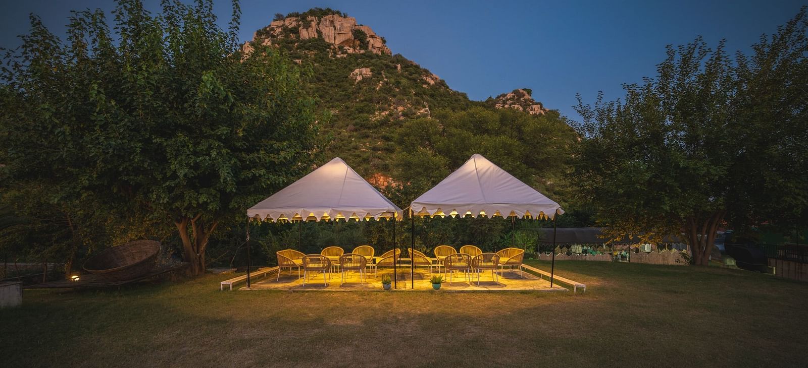 Night view of an open dining space adorned with sheer curtains and glowing lights at Valley by Grassfield.