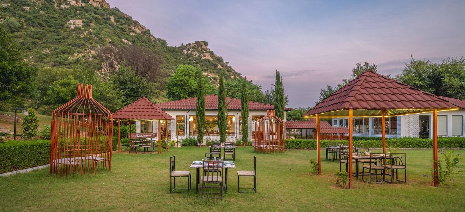 An open space at Valley by Grassfield, featuring tables and chairs, with mountains providing a stunning backdrop.