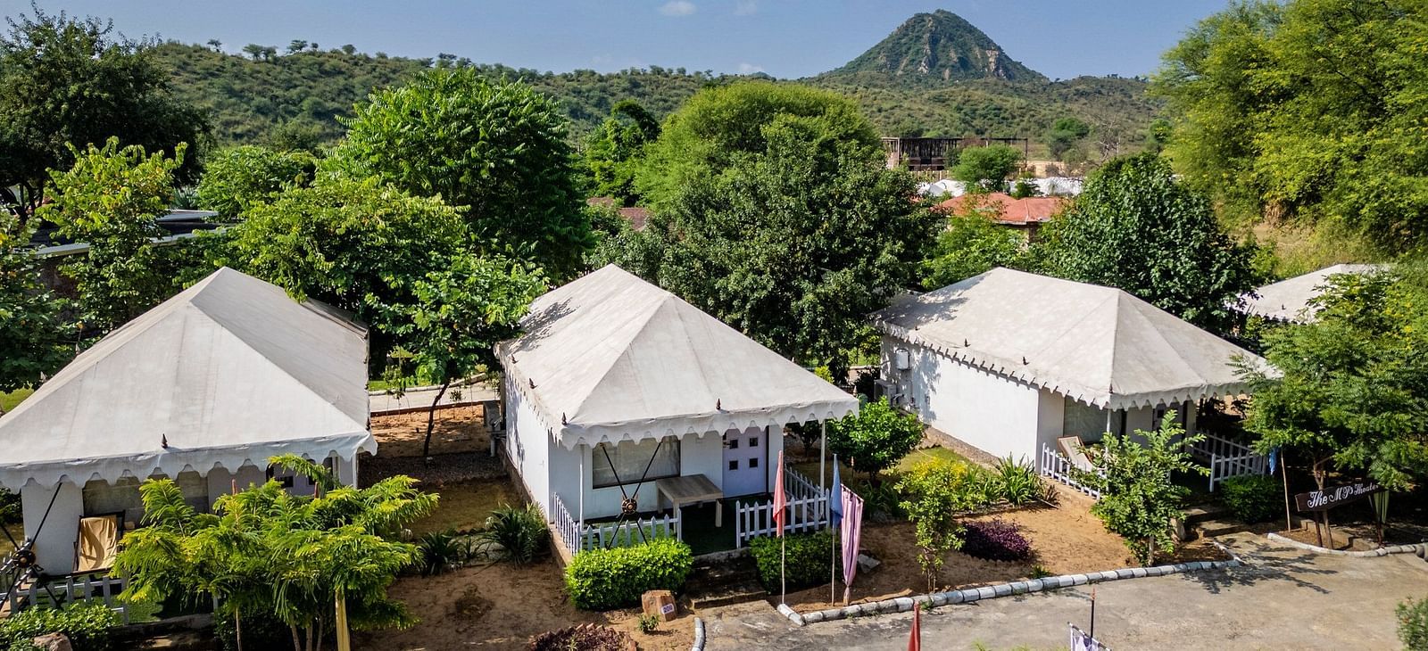 Aerial view of tent-style accommodations at Valley by Grassfield, nestled amidst lush trees and greenery.