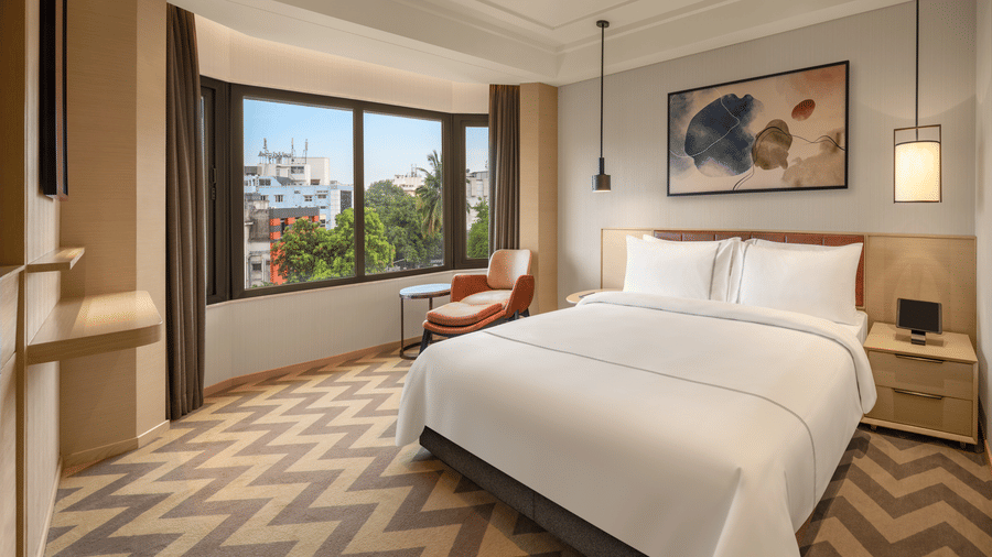 Suite room featuring a cosy bed and elegant bedside lamps at The Residency Chennai