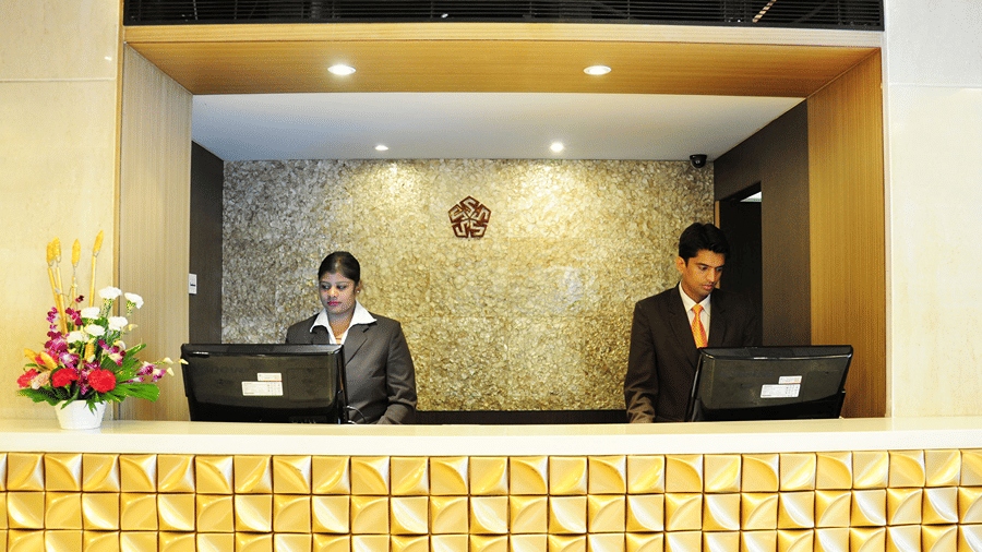 Front view of the reception of the Senses Hotel with two staff members dressed in business formals using the computers.