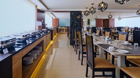 Table arrangement besides the buffet set up at Blue Salt and Coffee at Essentia Premier Hotel, Chennai