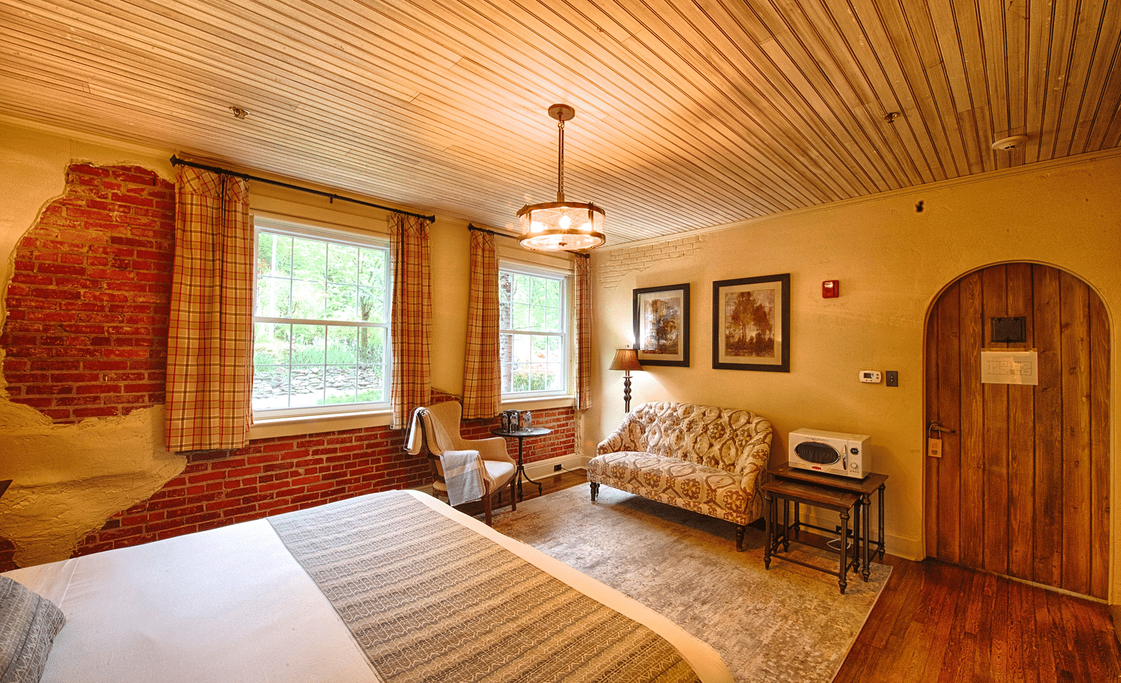 corner view image of a room featuring an arched wooden door with chic modern interiors - Historic Tapoco Lodge