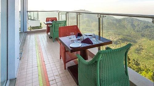 Two-seater balcony dining with a mountain view at Fragrant Nature Munnar