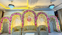 A stage decorated with floral arches, table and three big sofas at Silver Sand Sea Princess Beach Resort, Port Blair.