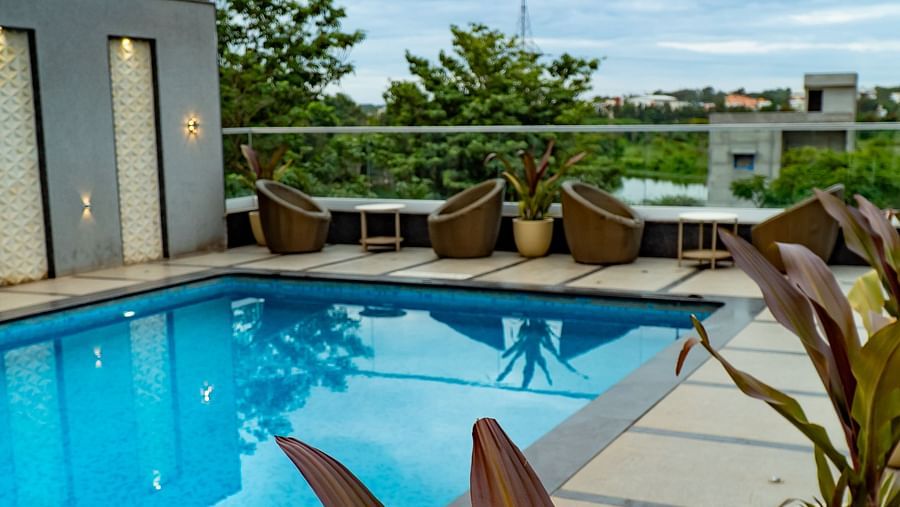 A swimming pool with lounge chairs under a bright sky.