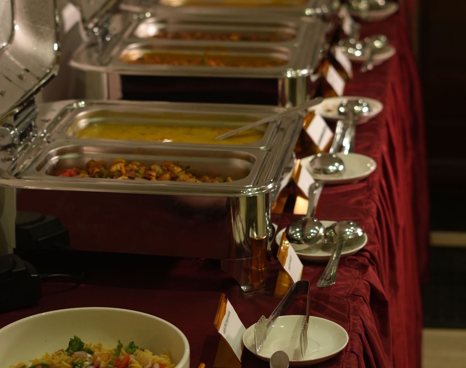 A close-up shot of the buffet counter in the restaurant featuring chafing dishes at WOW Naturefull Resorts.