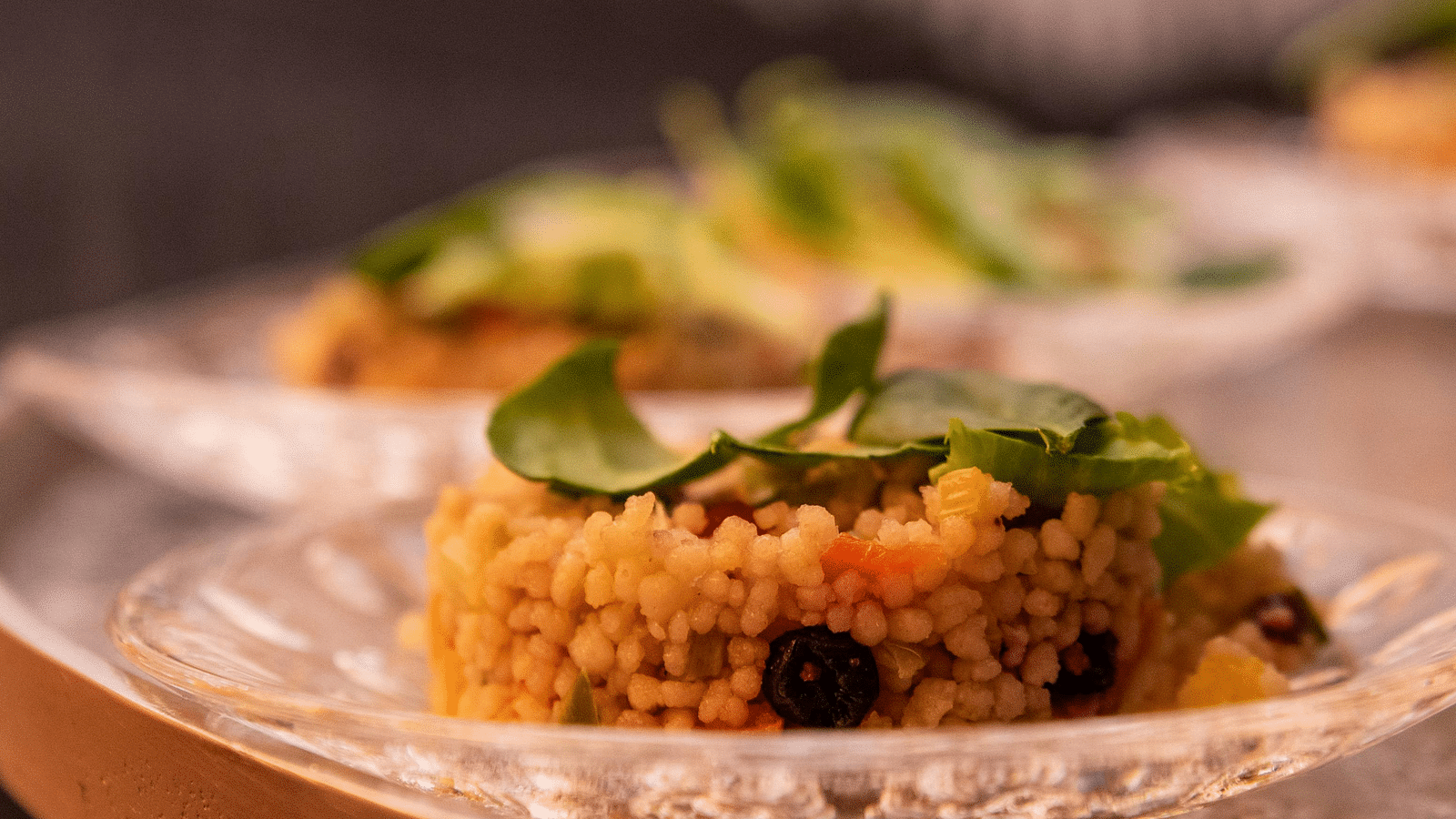 image of a dish made of rice served on a white china plate garnished with green veggies and herbs
