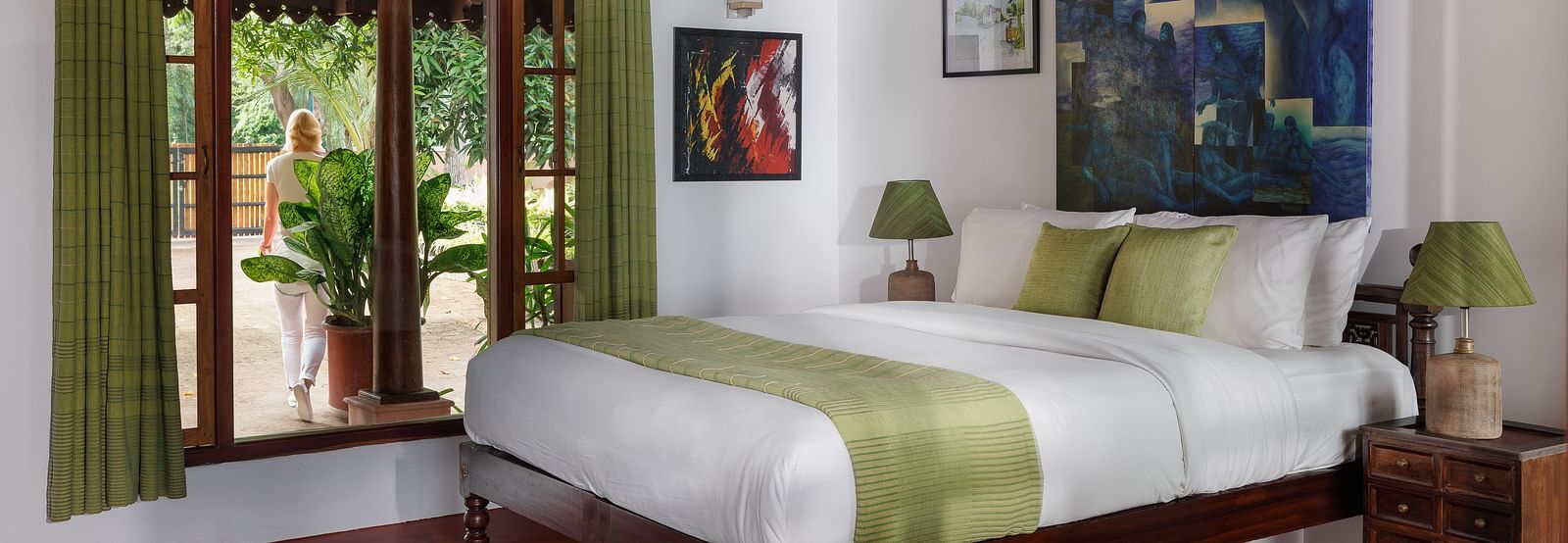 A room with a bed, wooden decorative items, and a glass window overlooking the view - BluSalzz Villas - Muhamma Resort, Alleppey