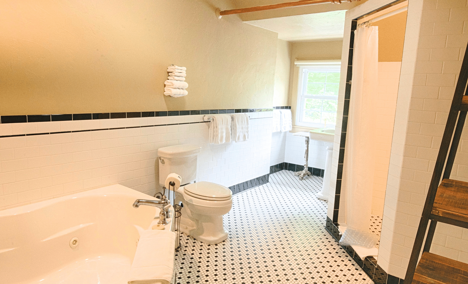 a wide angle view of the bathroom with black and white tiles along with a bathtub and a shower cubical - Historic Tapoco Lodge
