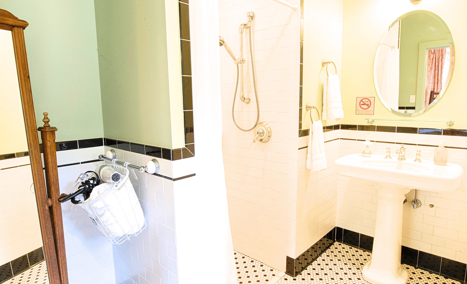 a bathroom with black and white patterned tiles along with a wash basin at the far end of the bathroom - Historic Tapoco Lodge