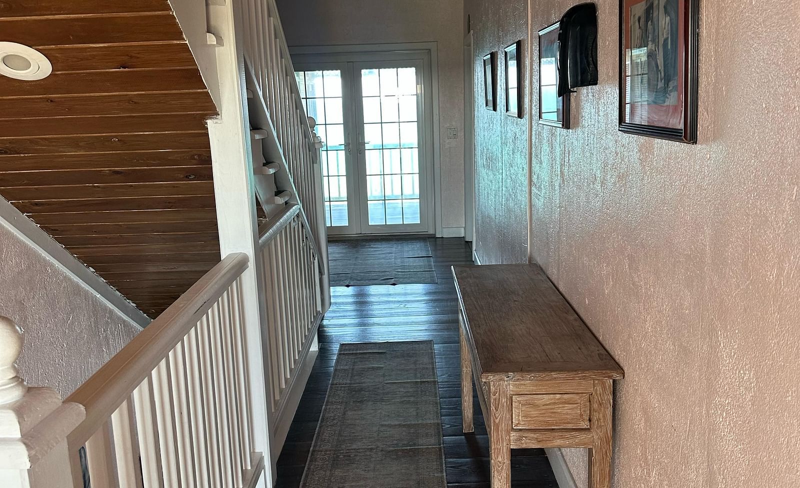 Indoor hallway with staircase and white railing | A Stone's Throw Away