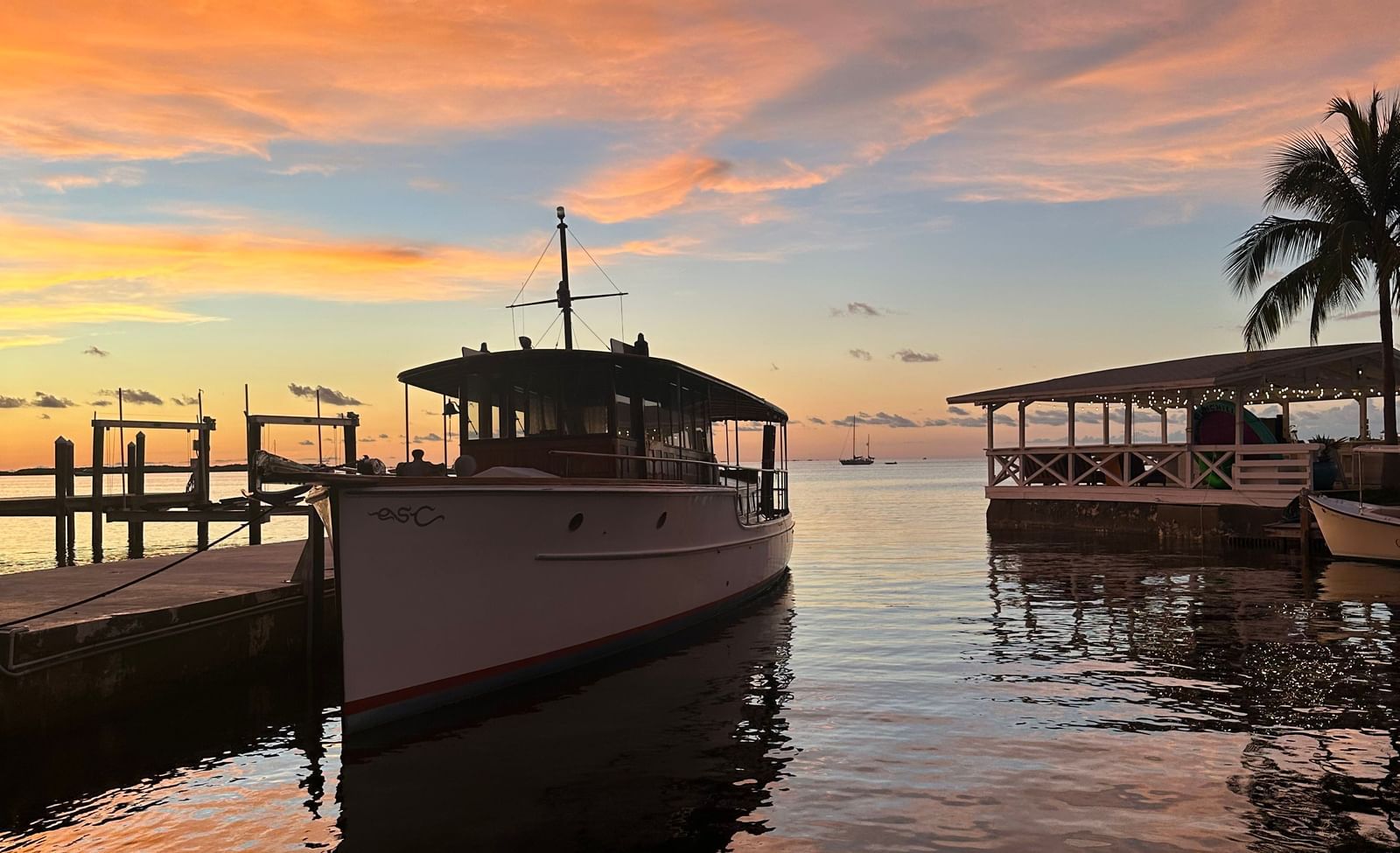 A silhouette of a sail boat docked in the calm waters with a mesmerizing sunset in the background at Casa Morada.