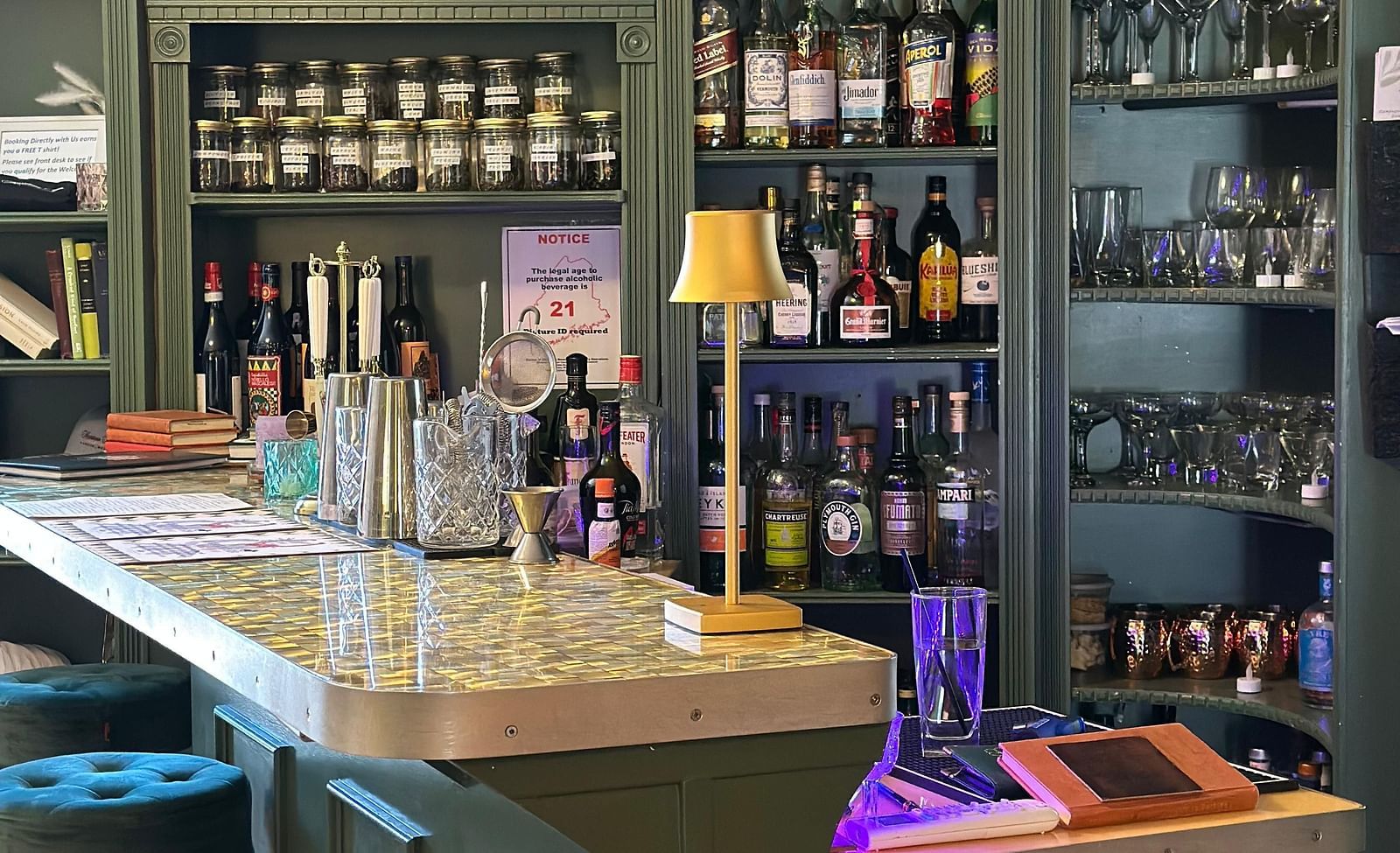 Upscale bar at Hartstone Inn stocked with a variety of liquor bottles, glassware, and cozy seating.