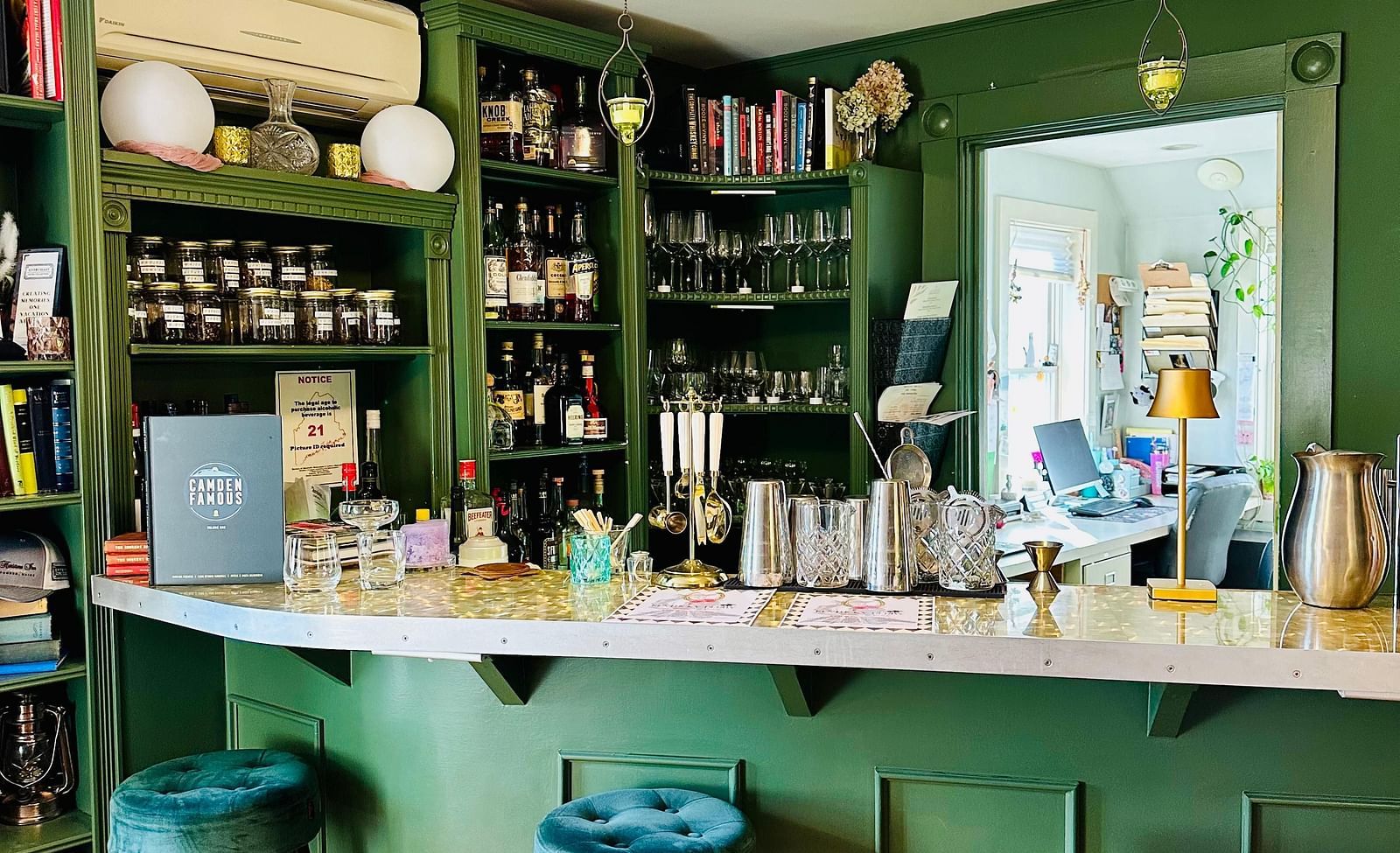 Stylish bar area at Hartstone Inn with teal stools, green cabinetry, and a well-stocked back bar in an intimate setting.
