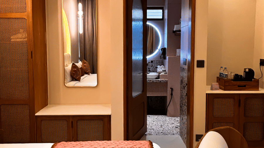 A view of a bed looking towards a wooden wardrobe and an open door leading to a bathroom at Avanya Resorts N Retreat.