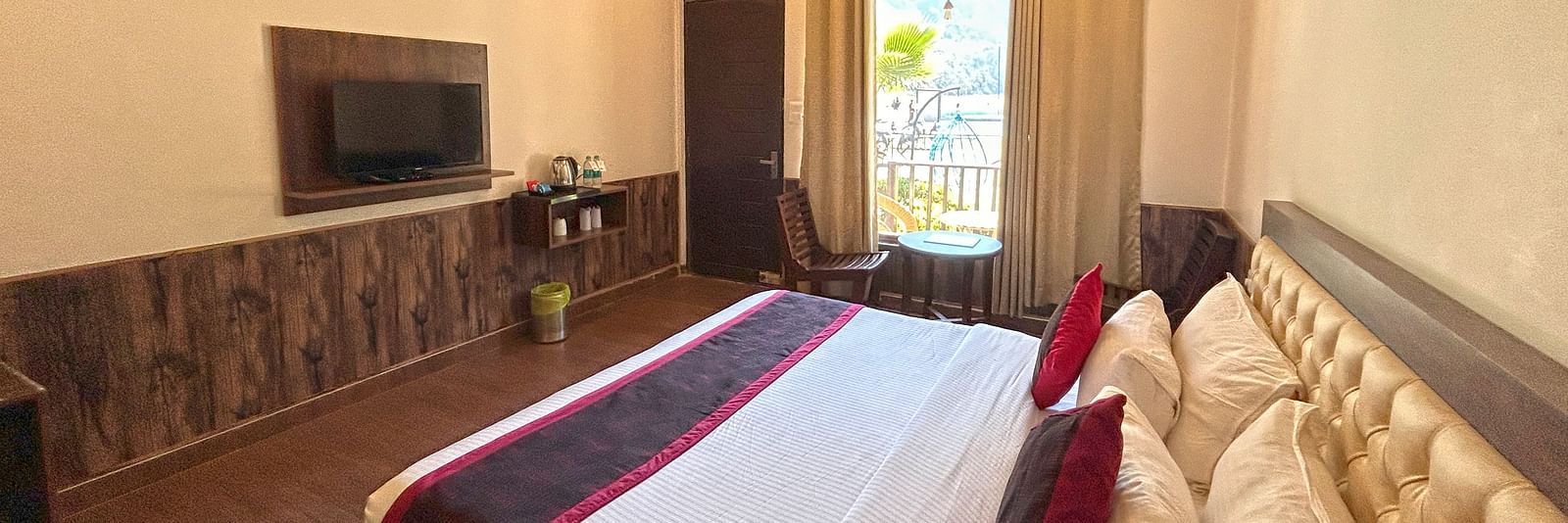 A Luxury Cottage with a large bed in front of the TV at DLS MJ River Resort, Rishikesh.