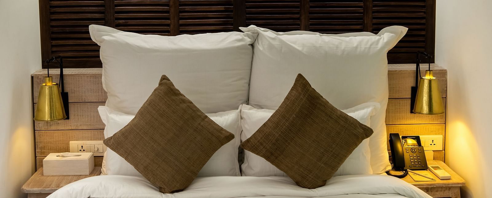 The Standard room featuring a bed with pillows and cushions along with bedside table and lamps - The Nanee
