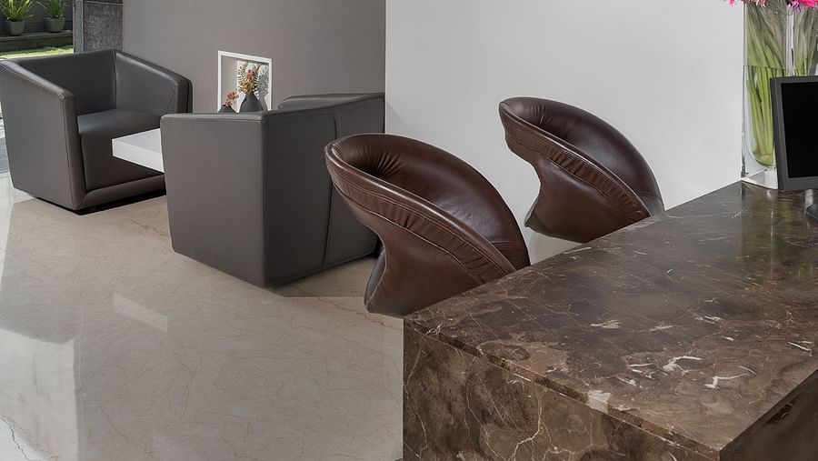 A cosy corner of a room at The Atara is furnished with two comfortable armchairs, a small side table, and multiple framed artworks adorning the walls, creating an intimate setting