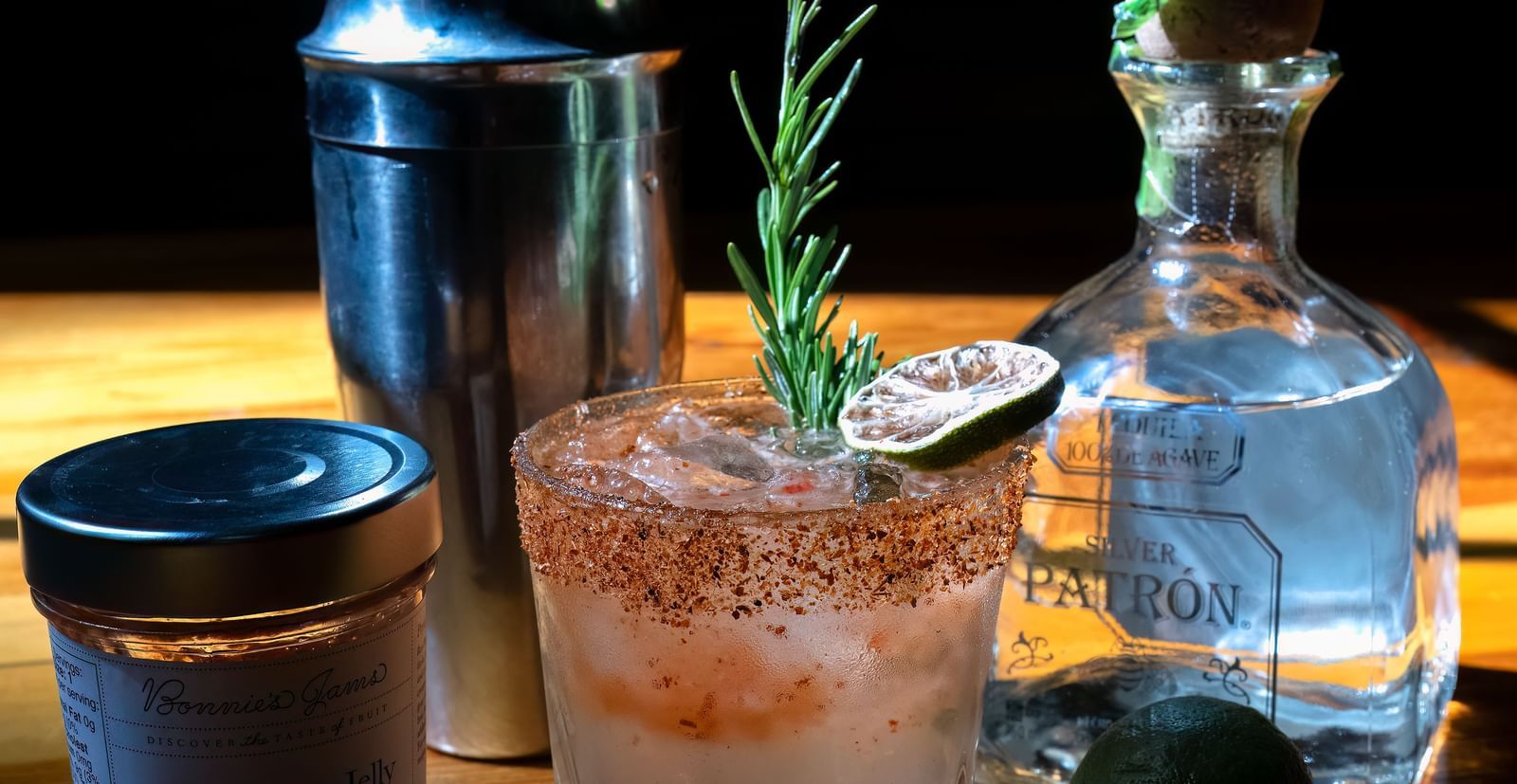 Craft cocktail setup with limes, shaker, and clear spirits on a wooden bar at Narrow Gauge Inn.