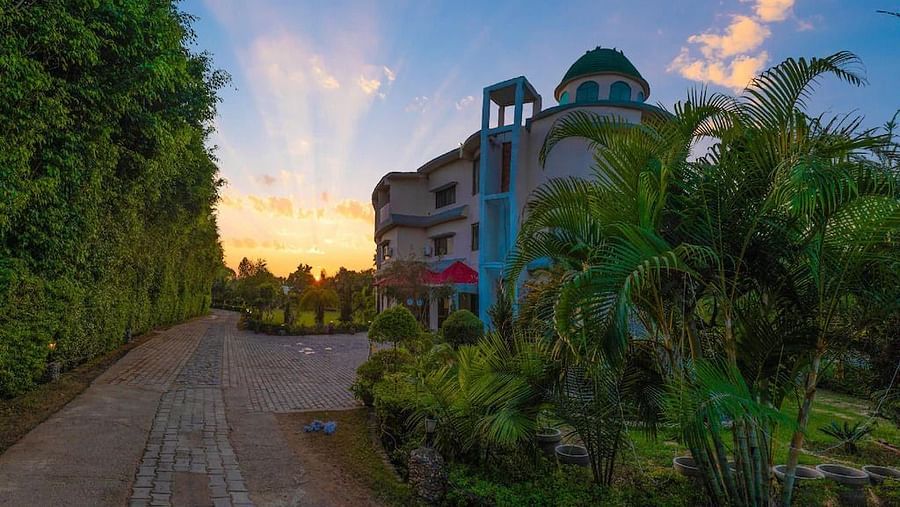 Sunrise view at Tattwaa Corbett Spa & Retreat, with lush greenery and serene pathways leading to the main building.