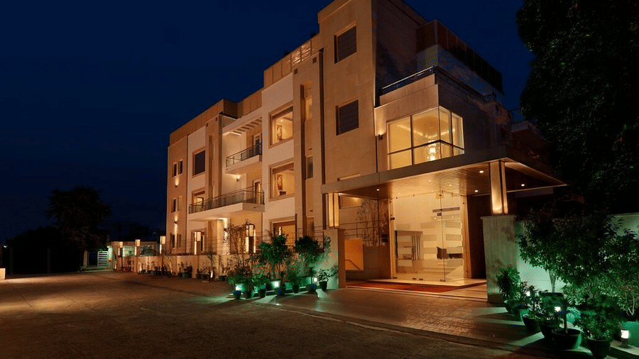 The exterior of Eastlynn Collections Huda City Centre, Gurugram, is warmly illuminated against the dark night sky.
