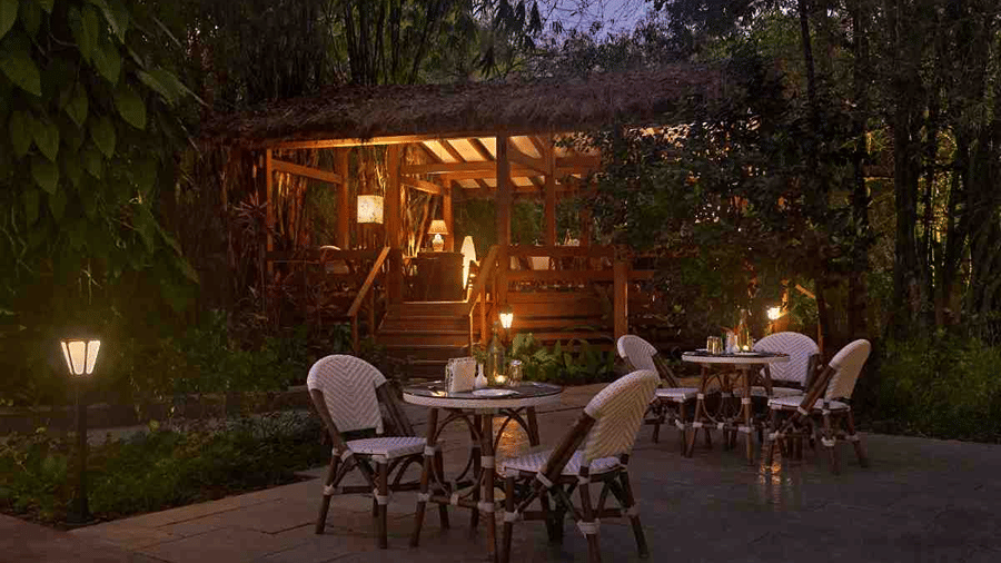 Garden dining area lit up at night at Amanvana Spa Resort, Coorg