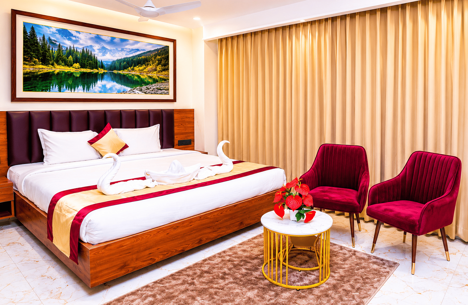A spacious Executive Room at Hotel Galadari featuring a bed with towel swans, a seating area with 2 chairs, and a nature painting on the wall.
