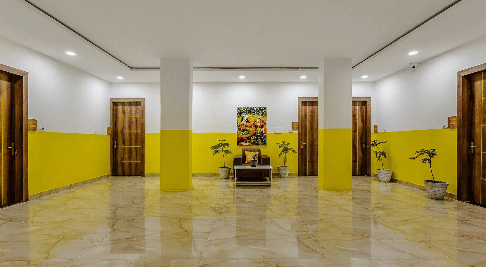 A large indoor hall with yellow and white walls, and minimal furnishings - Lime Tree Hotels & Banquet, Vrindavan