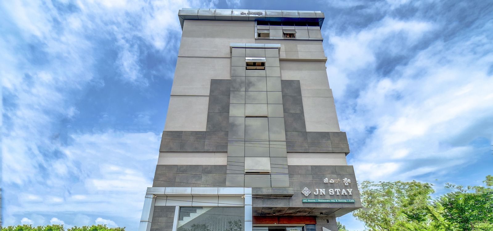 Facade view of Harigovinda's JNStay from the front against a cloudy sky