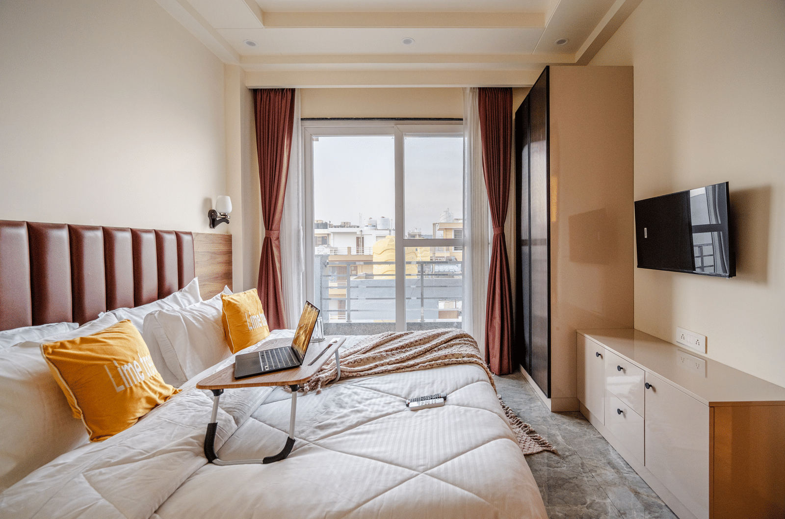 Bright and airy room with a large bed, TV, and natural light at Lime Tree 1BHK Service Apartment Near Artemis Hospital Gurgaon.