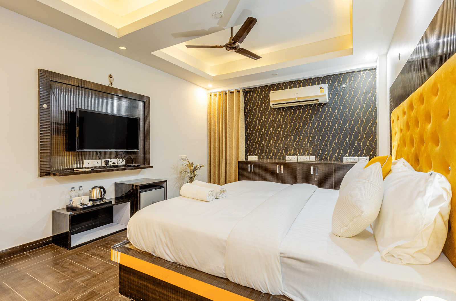 Side view of the king size bed with television in front of it in the superior King room at Lime Tree Hotels and Banquet Hall Near Huda Metro, Gurgaon