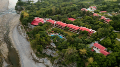 Resort nestled in a peaceful river valley surrounded by greenery.