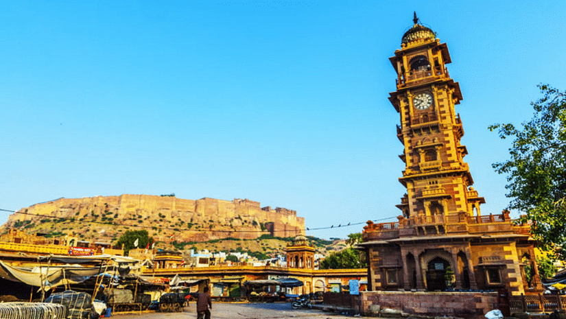 A wide-angle view of the Clock Tower, with the fort in the background, bustling with people roaming around and enjoying the vibrant atmosphere.