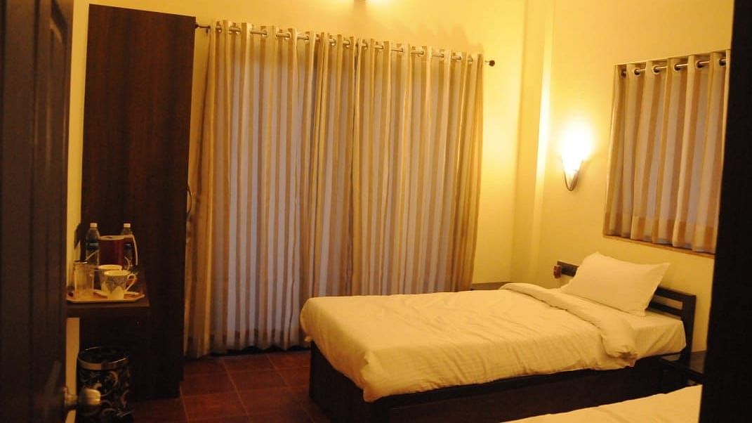 A bedroom with a single bed, wardrobe, and warm lighting.