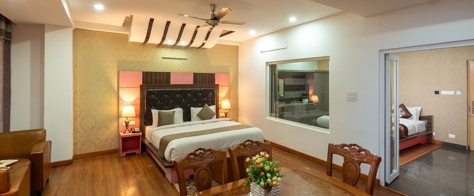 Dining area and double bed of the Family Suite of DLS Hotel Shiva Sanctuary & Spa in Dharamshala.