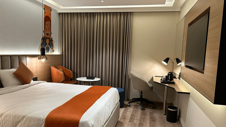 A room with a bed, a couch, a coffee table, a work desk, and a chair - TGI Oberon, Koramangala