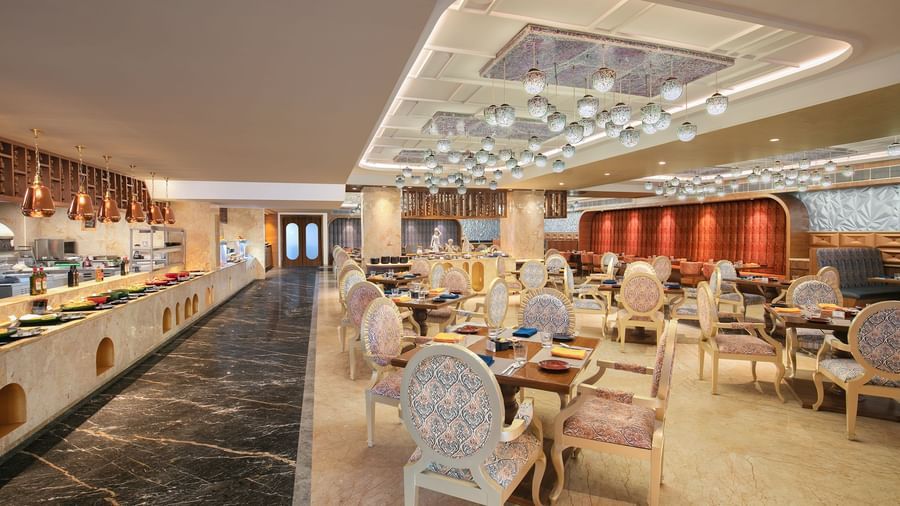 A lavish buffet area with artistic ceiling designs and refined seating arrangements at our restaurant in Mahabalipuram - Kaldan Samudhra Palace