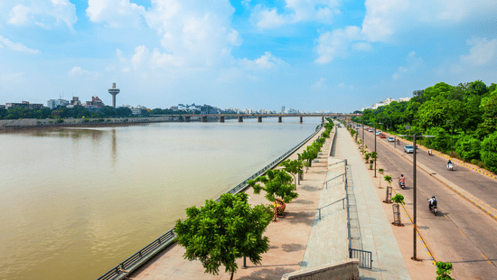 Sabarmati Riverfront walkway and road with greenery and city skyline in Ahmedabad