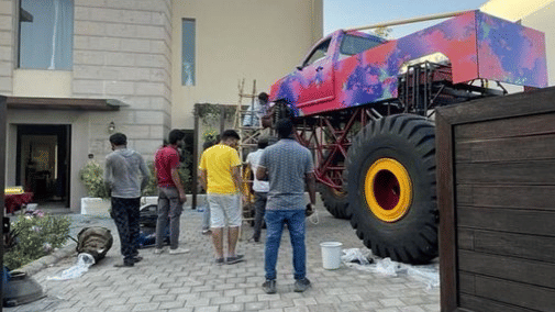 a group of people next to a monster car during a photoshoot - Karma Lakelands.