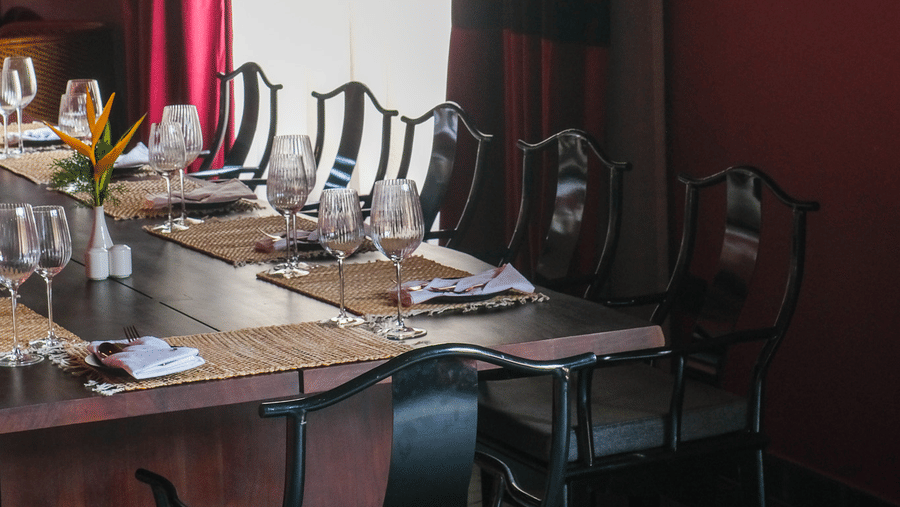 Indoor dining ambience at Baan Kahi restaurant featuring elegant table settings and warm interiors at Rhino and River Wildlife Retreat & Spa in Pobitora