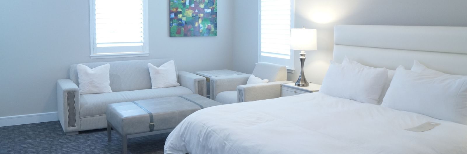 A stylish bedroom featuring a large bed, soft lighting, and minimalist furniture, designed for a comfortable stay - The Grand Hotel & Ballroom, McKinney