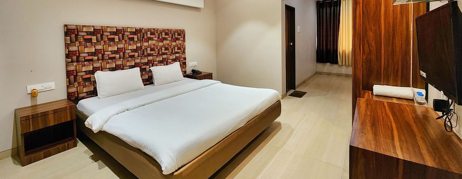 A Premium Room at The Kanila Resort featuring a bed, a desk, and a wardrobe.