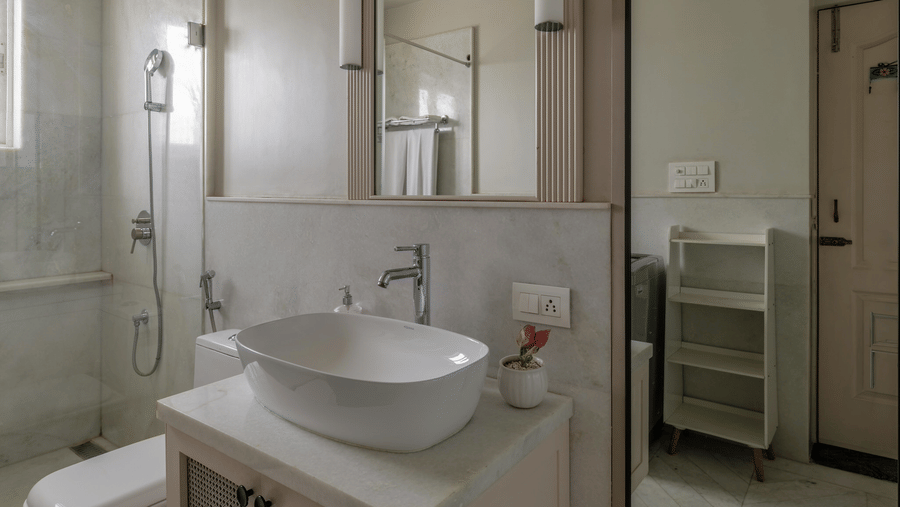 Bathroom with double wash basins, a large mirror, and a glass shower partition at Barwara Kothi, Jaipur.